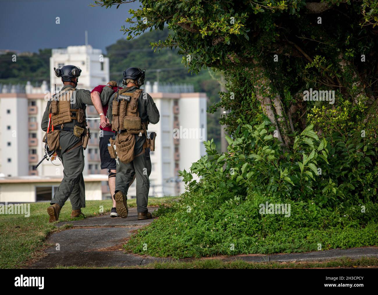 U.S. Marines with Special Reaction Team, Marine Corps Installation Pacific - Marine Corps Base Camp Butler, escort an active shooter during a notional, active-shooter scenario for Constant Vigilance 2021 on Camp Foster, Okinawa, Japan, Oct. 21, 2021. The exercise consisted of an active shooter injuring a casualty and then barricading himself into a building with two hostages. The SRT and Criminal Investigation Division responded and negotiated with the barricaded suspect which led to getting the hostages out safe. Constant Vigilance is an island-wide force protection condition evaluation and c Stock Photo