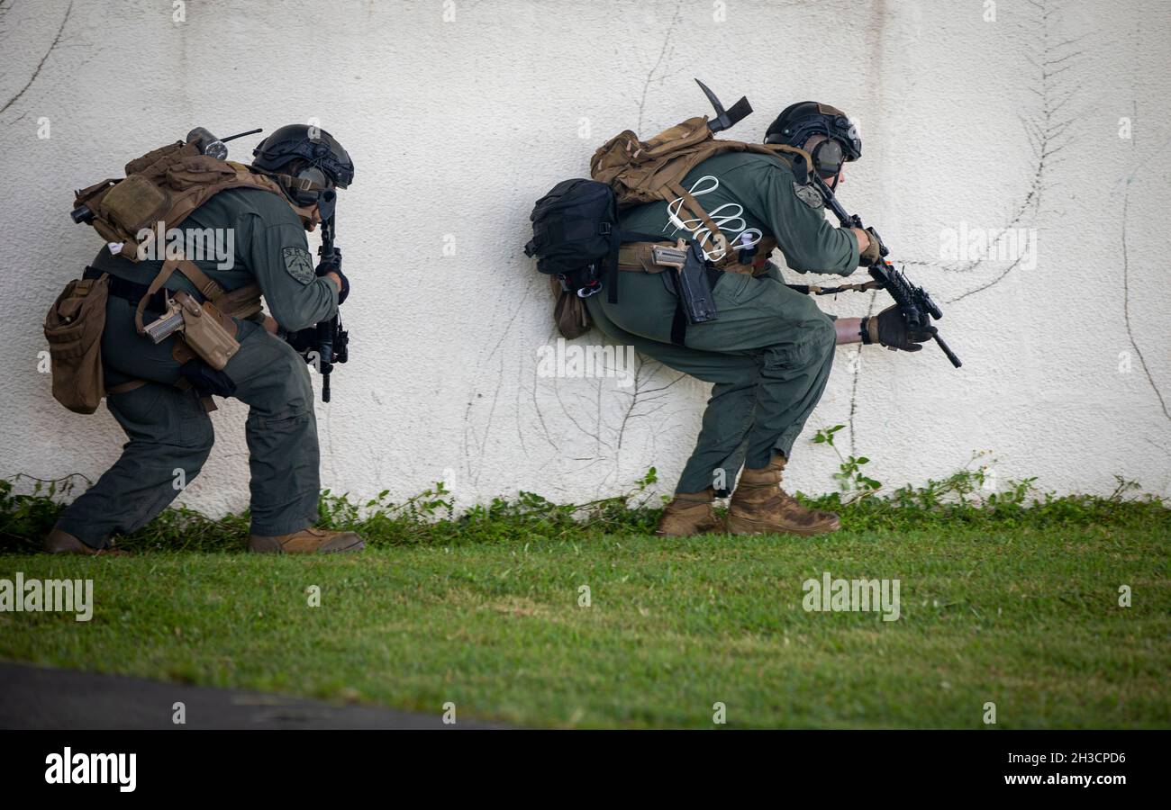 U.S. Marines with Special Reaction Team, Marine Corps Installation Pacific - Marine Corps Base Camp Butler, respond to a call during a notional, active-shooter scenario for Constant Vigilance 2021 on Camp Foster, Okinawa, Japan, Oct. 21, 2021. The exercise consisted of an active shooter injuring a casualty and then barricading himself into a building with two hostages. The SRT and Criminal Investigation Division responded and negotiated with the barricaded suspect which led to getting the hostages out safe. Constant Vigilance is an island-wide force protection condition evaluation and crisis r Stock Photo