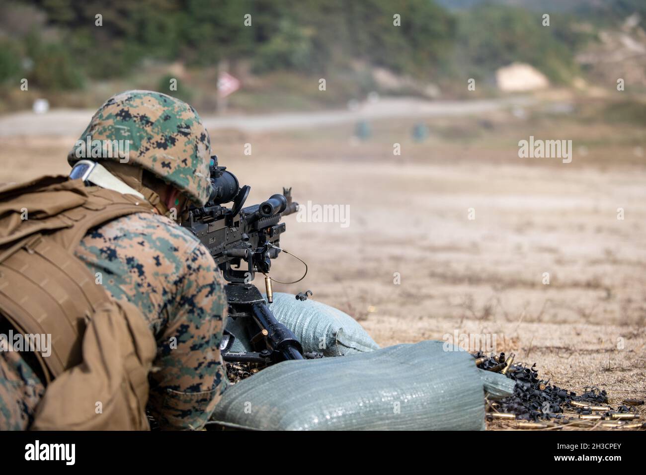 A U.S. Marine with 3d Maintenance Battalion, 3d Marine Logistics Group fires an M240B machine gun during a machine gun range during Korea Marine Exchange Program 22-1 at Camp Rodriguez, Pocheon, Republic of Korea, Oct. 16, 2021. Marines from 2d Battalion, 3rd Marine Regiment and 3d Maint. Bn. conducted bipod, tripod, and unknown distance qualification while sustaining the fundamentals of machine gun gunnery during day and night conditions. (U.S. Marine Corps photo by Sgt. Ash McLaughlin) Stock Photo