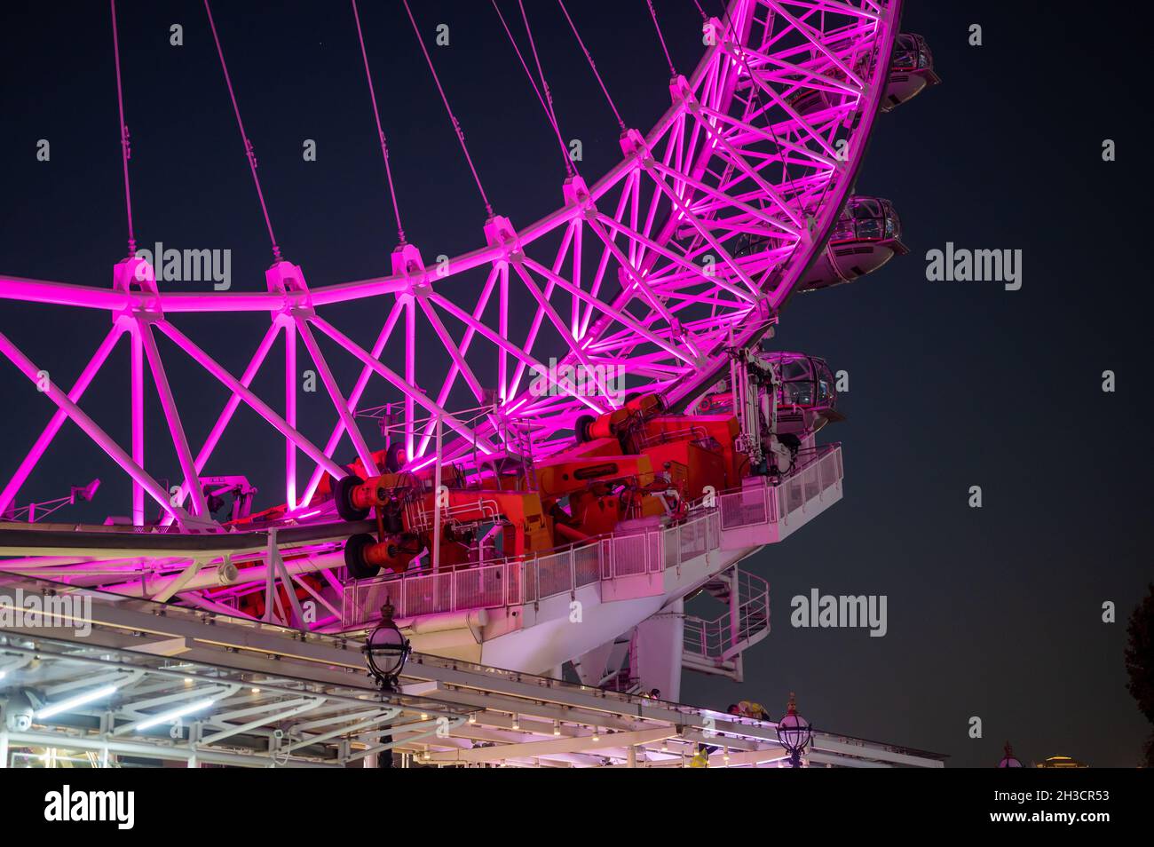 The motors that drive The London Eye, colourfully illuminated at night Stock Photo