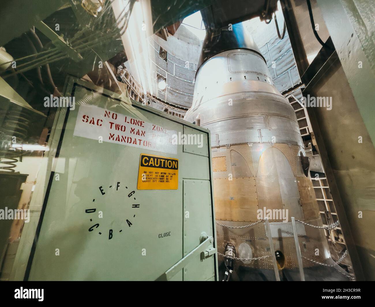 A heavy metal door at the top of the Titan missile silo sits ajar, allowing visitors to see the missile warhead Stock Photo