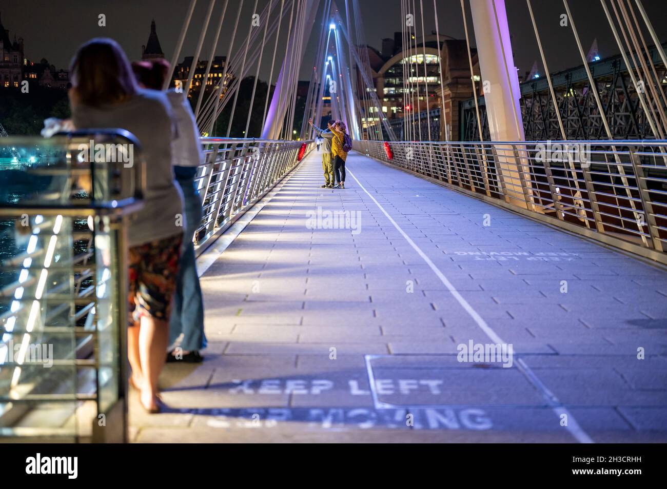 LONDON - SEPTEMBER 14, 2021: Tourists on Golden Jubilee foot bridge at night Stock Photo