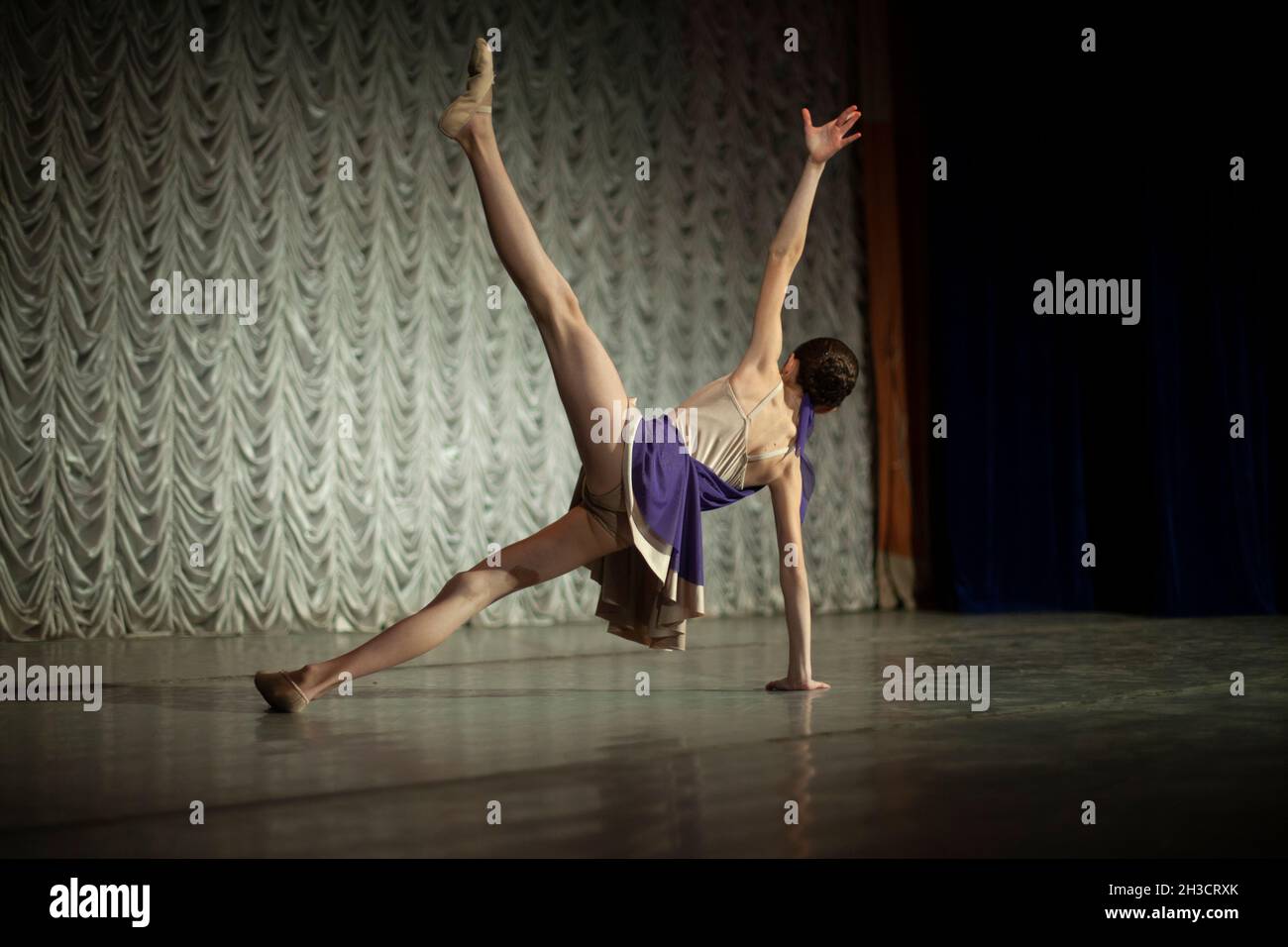 Dancer on stage. A girl in a purple dress. Dance lesson. Stock Photo