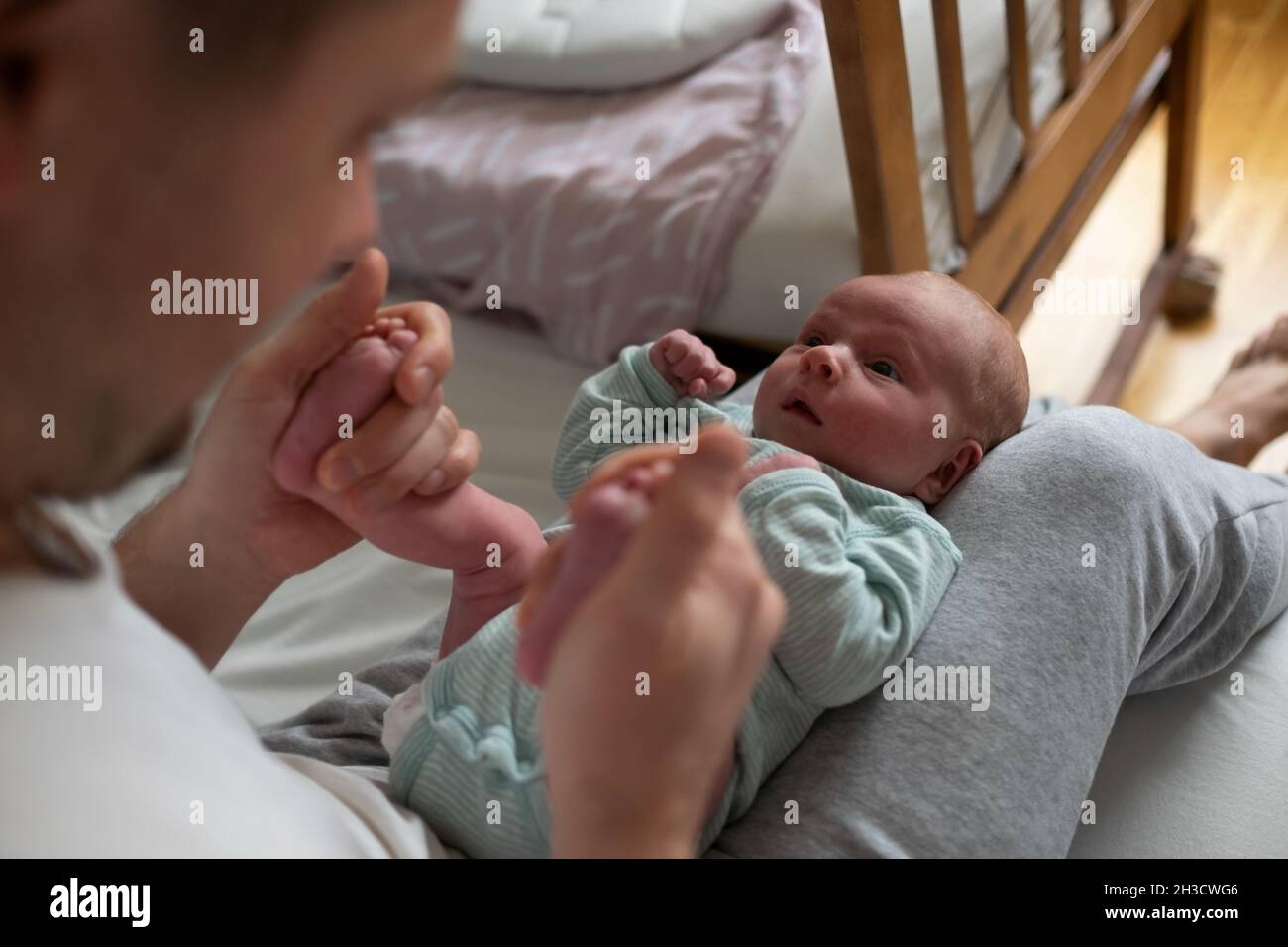 Hands holding baby feet checking reflex of a newborn Stock Photo Alamy