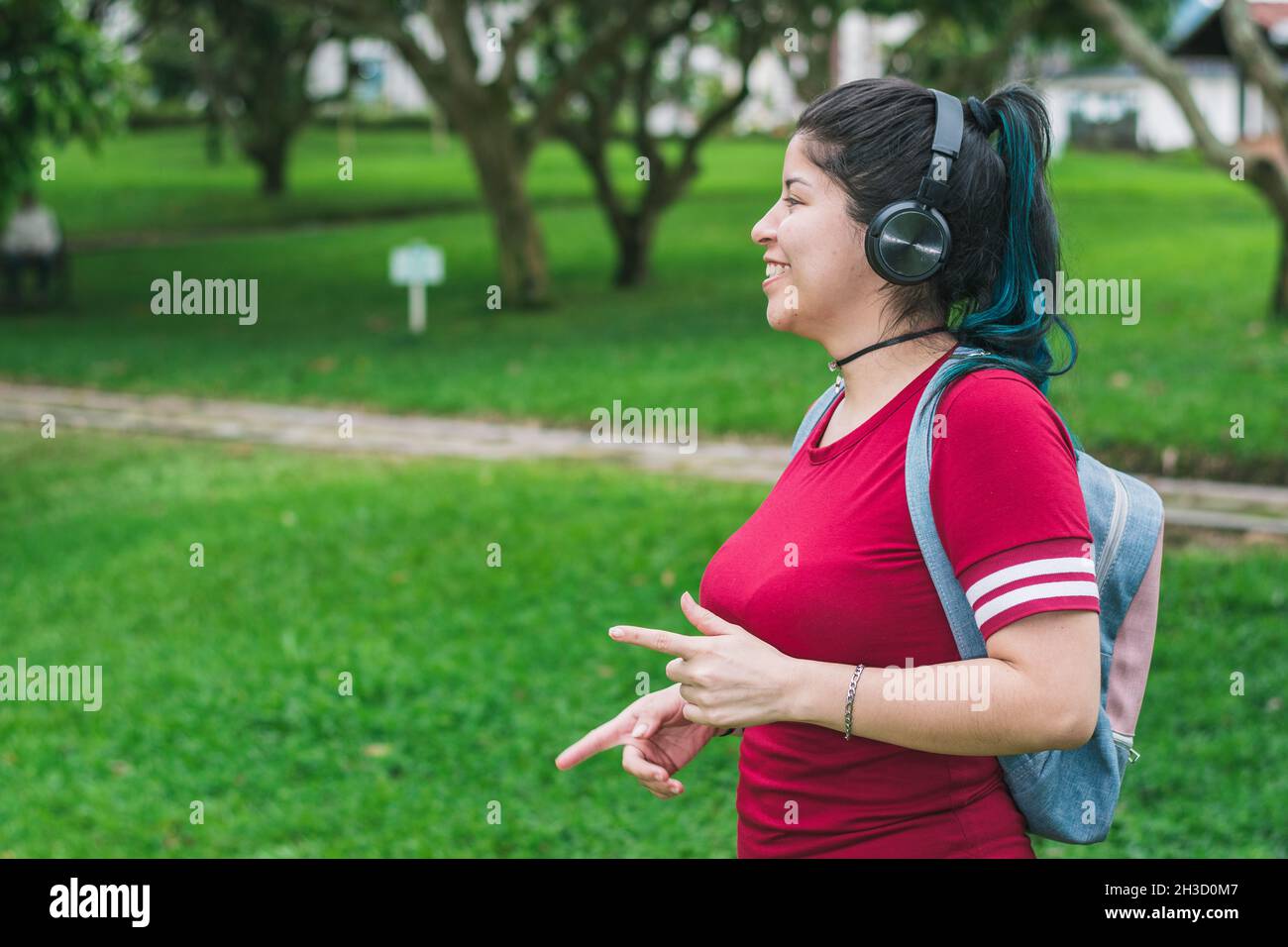 beautiful college woman with blue hair and a red dress, listening to ...