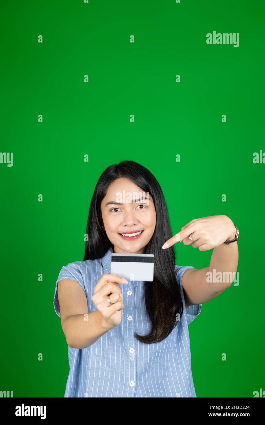 asian woman looking at camera while holding atm card with hand gesture
