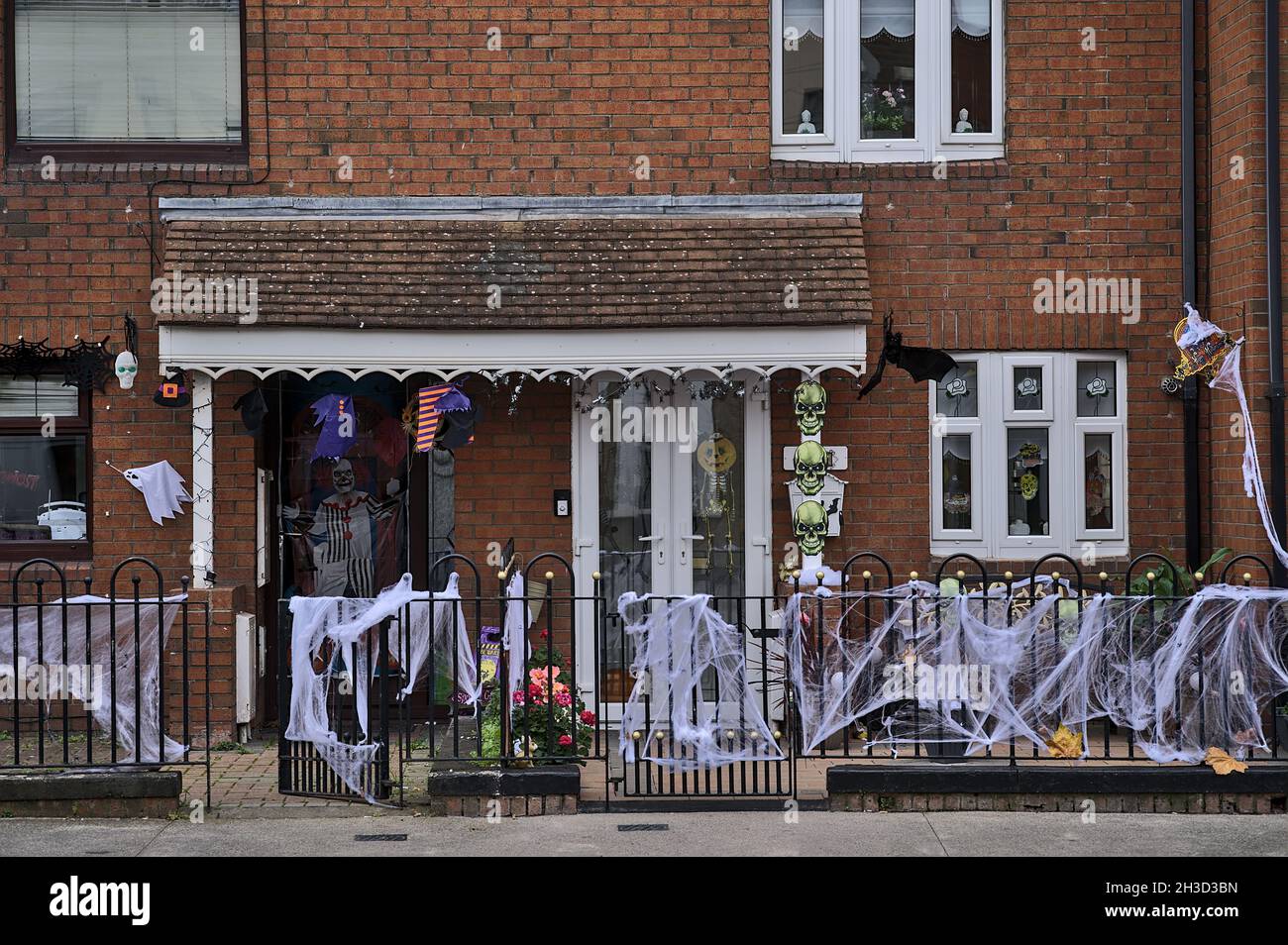 Beautiful and spooky Halloween decor on metal fence and typical Irish house in Dublin City Centre. Halloween 2021 decoration on the wall beside door Stock Photo