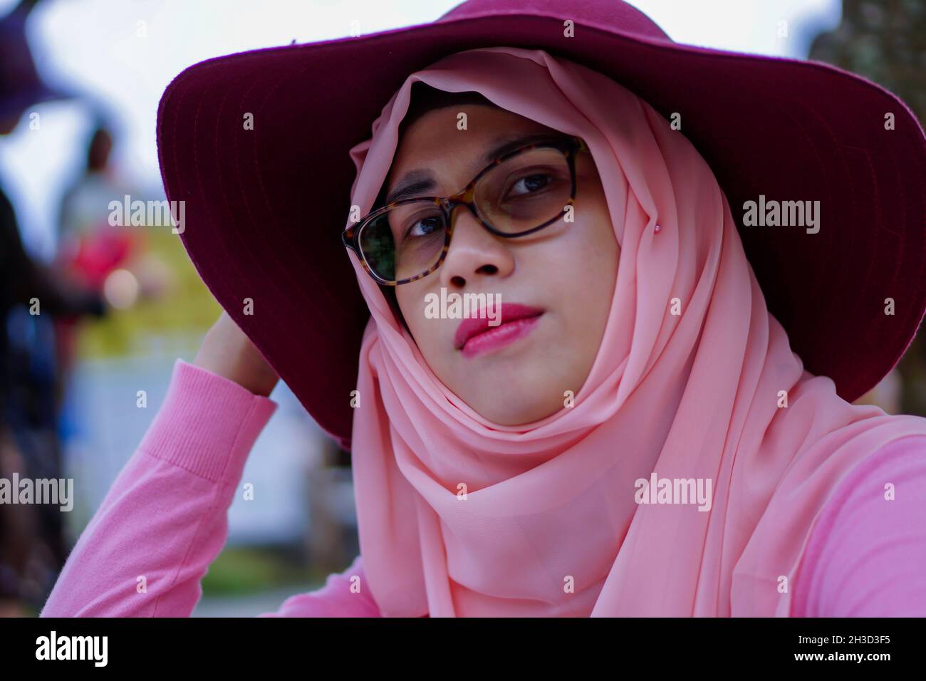 Close up portrait of beautiful young Asian muslim woman wearing hat ...