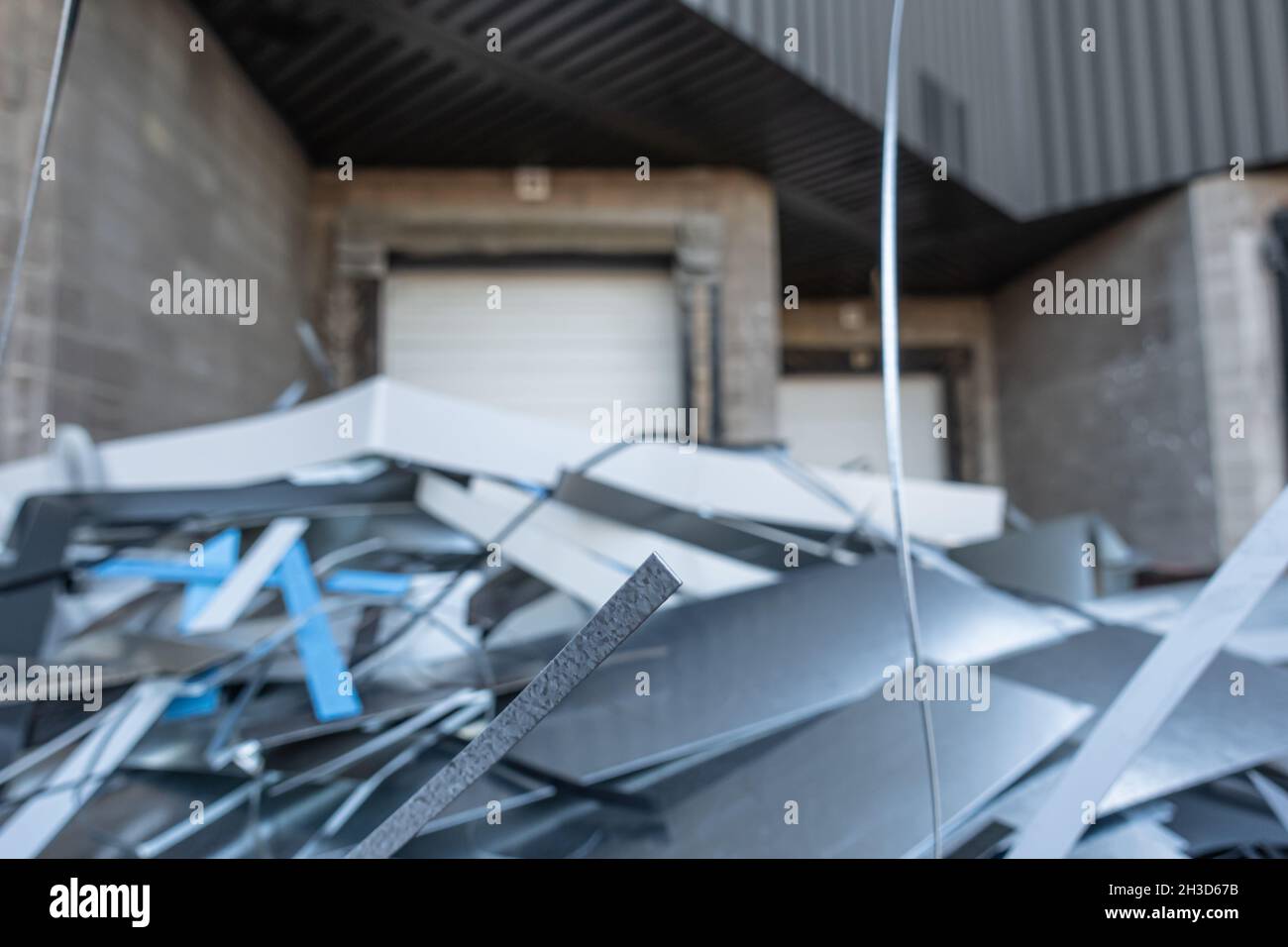 Garbage bin full of waste metal behind metal roofing factory Stock Photo