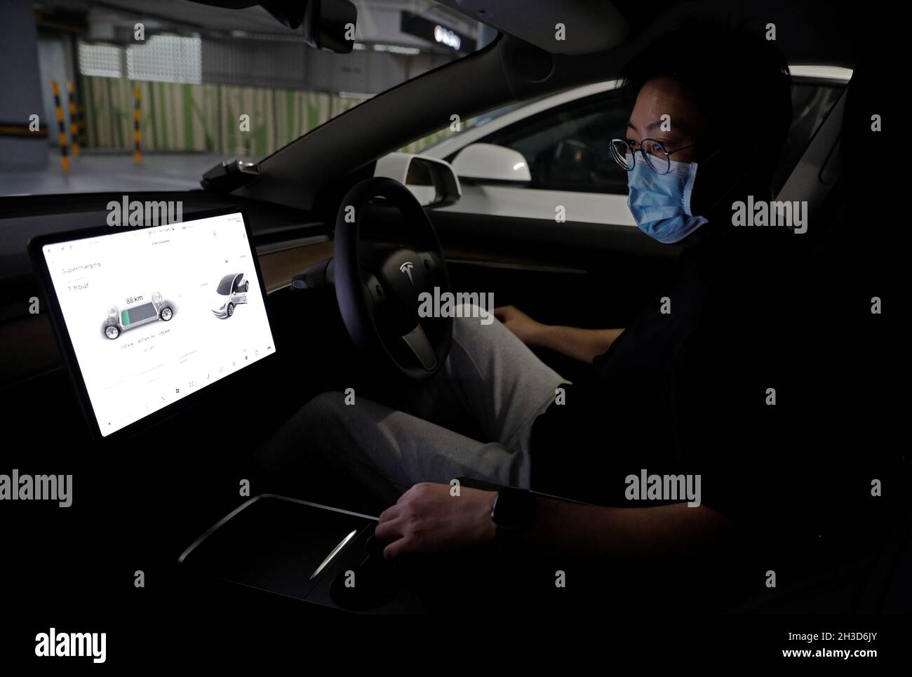 Tesla car owner Tim Shim, 42, prepares to charge his car at a