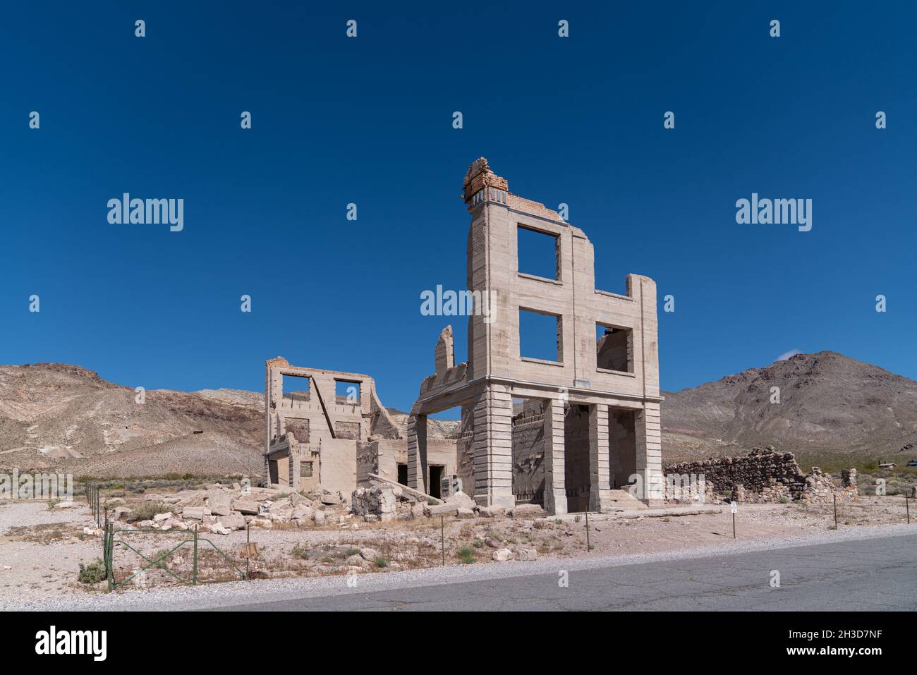 Wide shot of Deserted Ruined Bank Building in Rhyolite Ghost Town, Death Valley, Nevada, USA Stock Photo