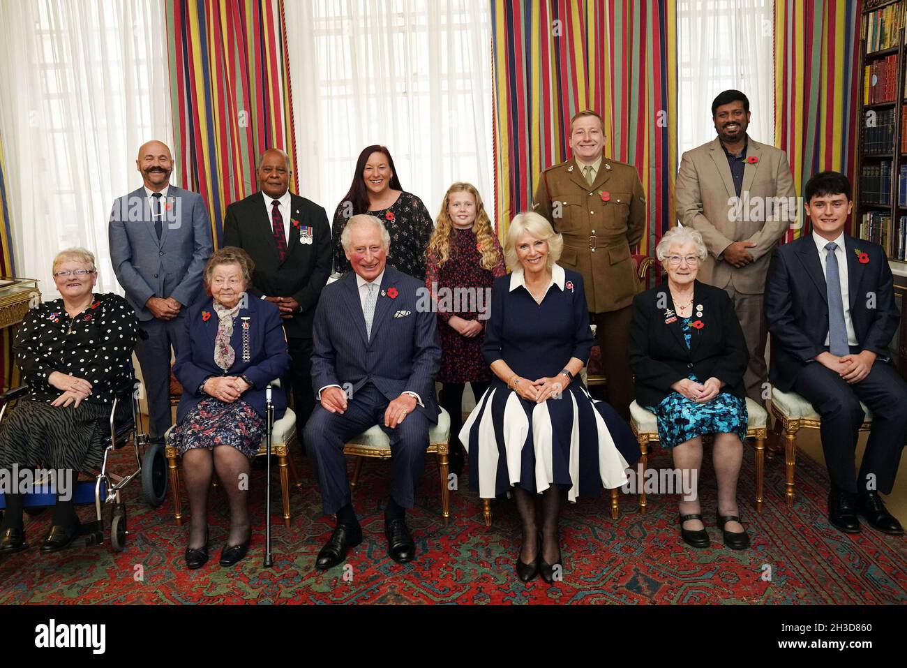 The Prince of Wales (front centre) and Duchess of Cornwall (third right front), with ten Royal British Legion (RBL) Poppy Appeal collectors: (front row L-R) Lesleyanne Gardner, Jill Gladwell, Vera Parnaby, Billy Wilde, and (back row L-R) David Kelsey, Andy Owens, Anne-Marie Cobley, Maisie Mead, Lance Corporal Ashley Martin and Mirza Shahzad at Clarence House, London, during the official launch of the centenary poppy appeal. Picture date: Tuesday October 26, 2021. Stock Photo