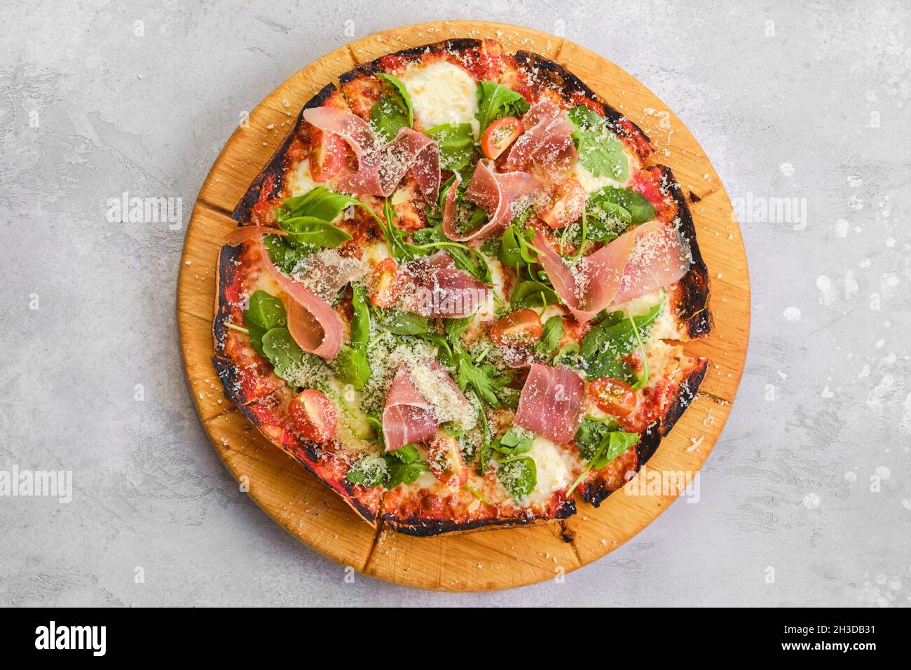 Thin-crust pizza dough with prosciutto ham Stock Photo