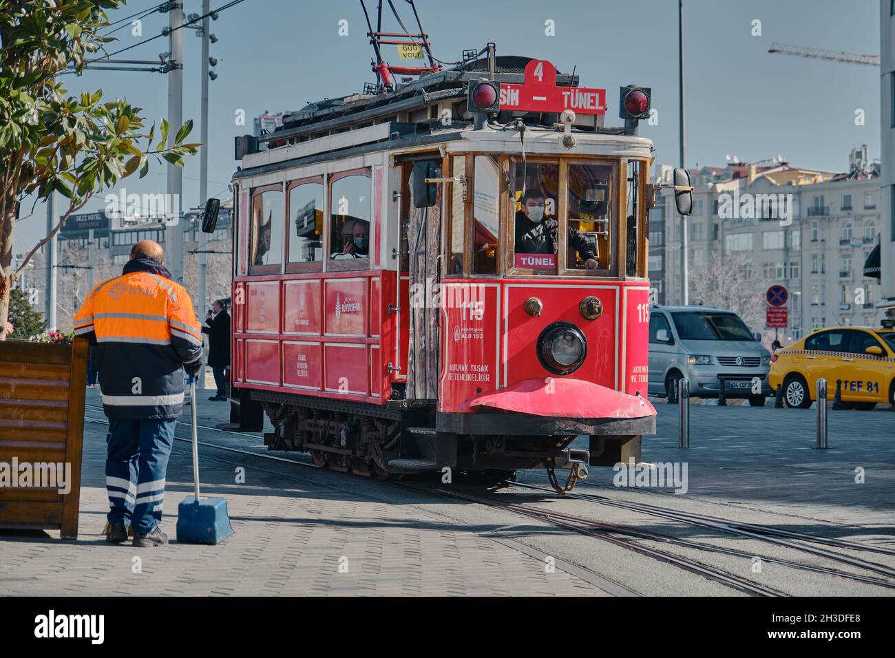 Most well known taksim square during morning with red, vintage and retro style tram in istiklal avenue and many tourists with medical masks. Stock Photo