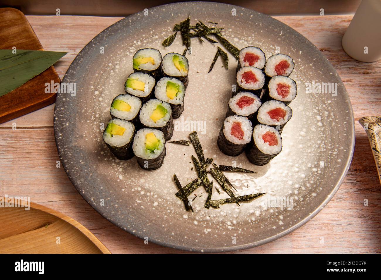 Decorative gray plate with fresh red tuna maki, marudo avocado rolled in  nori seaweed with white rice and Japanese vinegar Stock Photo - Alamy