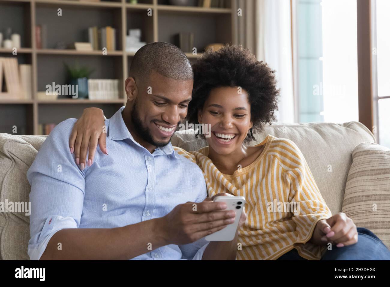 Happy beautiful young african american couple using cellphone Stock ...