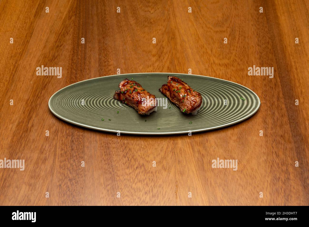 Japanese roasted wagyu beef nigiri on white rice taco with chopped chives Stock Photo