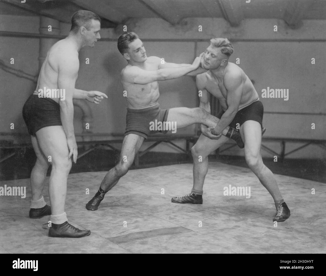 Wrestling in the 1930s. Swedish olympic wrestling champion Ivar Johansson 1903-1979 to the left wrestling with american wrestler Baker. Both wrestlers appears to have grips on each other and it's difficult to tell who has the overhand. Stock Photo