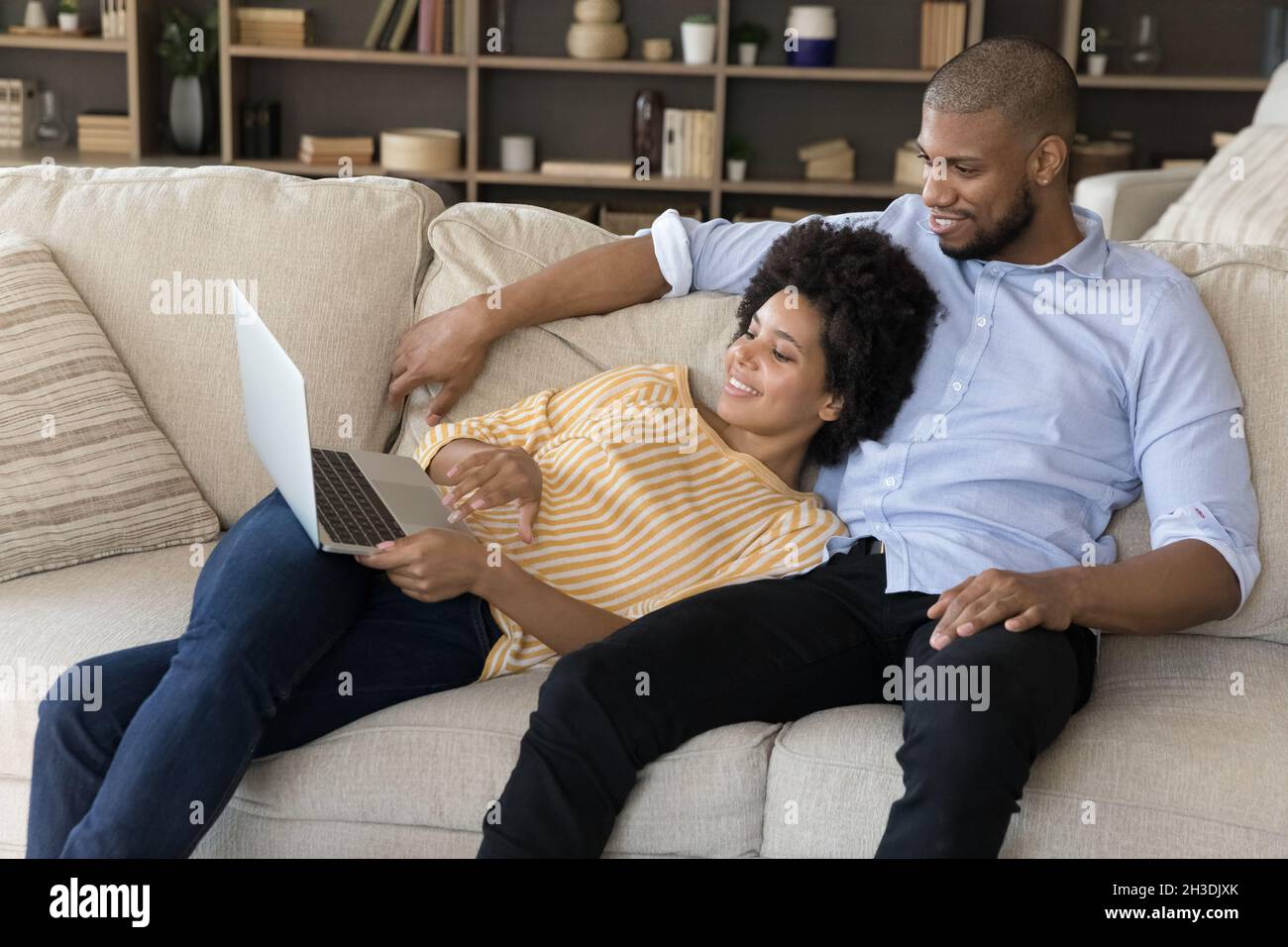 Happy relaxed young african american family couple using computer. Stock Photo