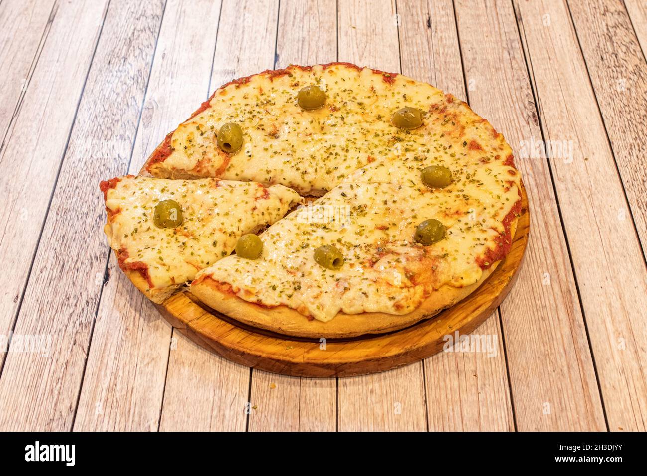 Pizza with lots of melted cheese and tomato, oregano with green pitted