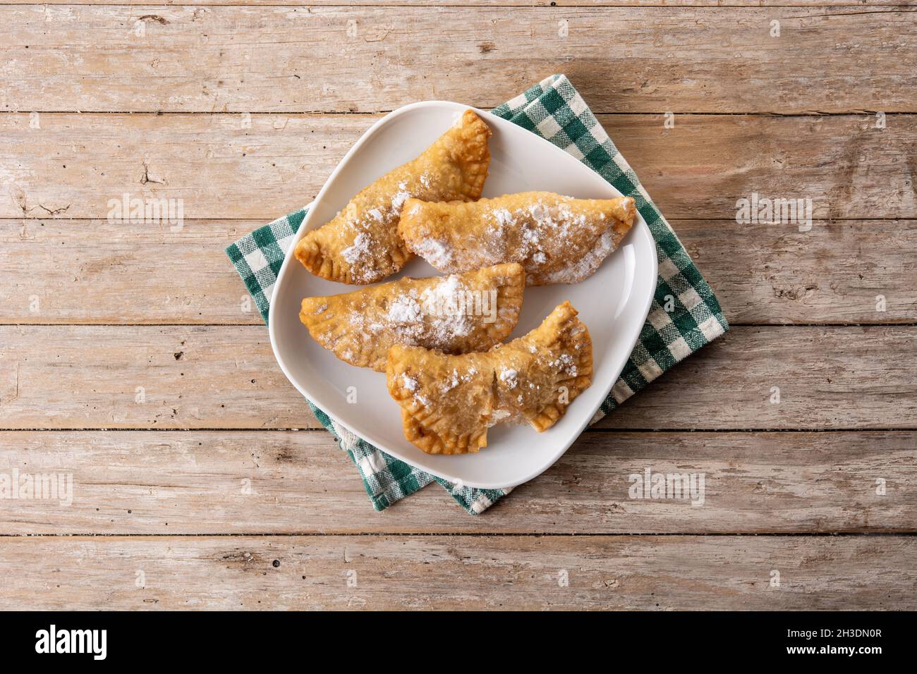 Spanish sweet stuffed pastry filled with angel hair on wooden table ...