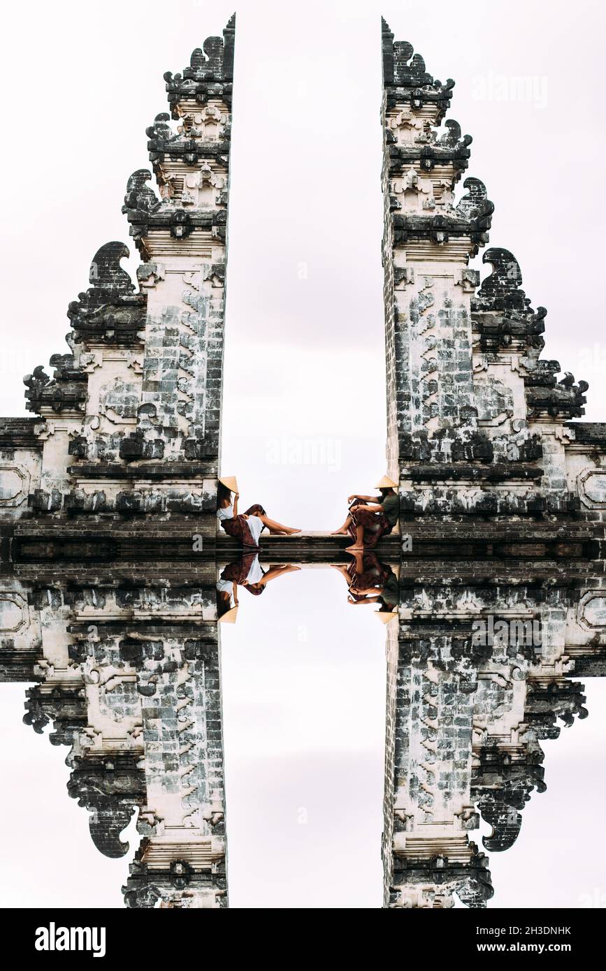 Couple at the Bali gate. A man and a woman traveling on the island of Bali Indonesia. The couple travels the world. Couple at the split gate of Candi Stock Photo