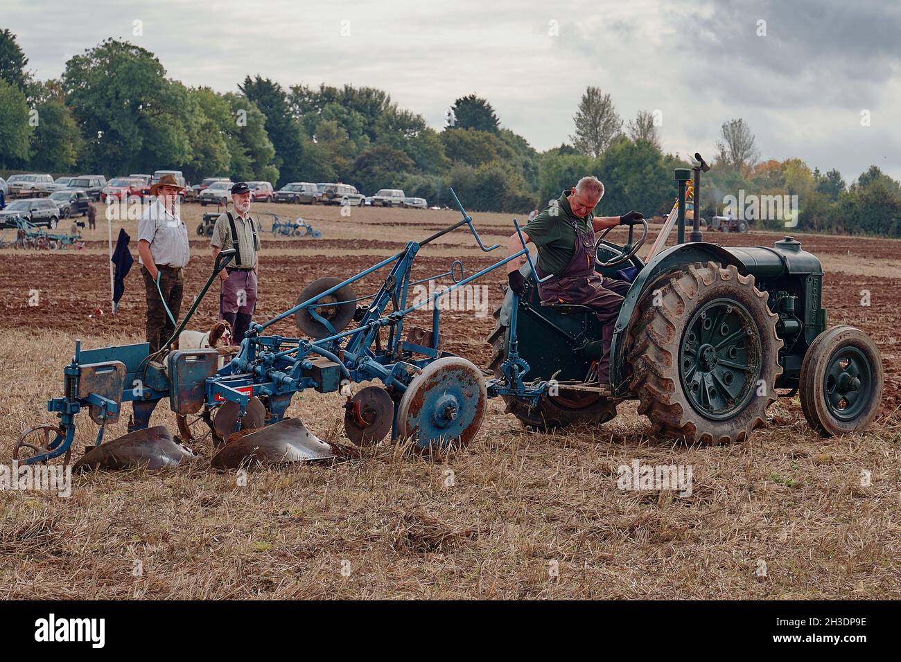 Side view of green tractor and plough at British Vintage Ploughing Match Stock Photo