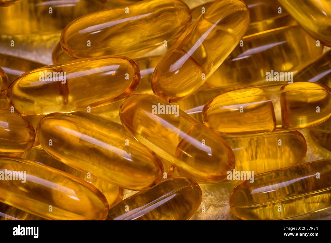 Omega-3 fish fat oil capsules as background texture. EPA and DHA are essential fatty substances that our bodies need on a daily basis. Stock Photo