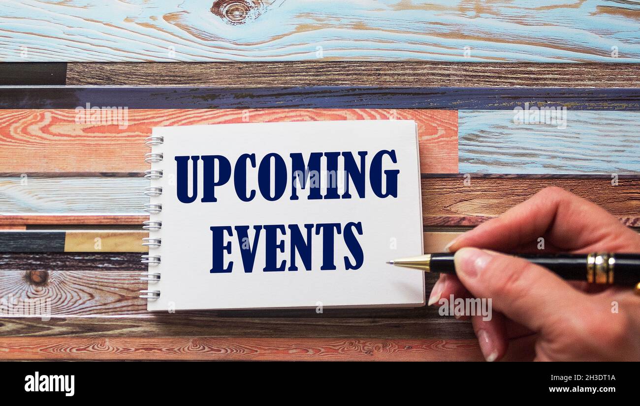 Concept message on a notebook is written by a female hand on a wooden table. Stock Photo