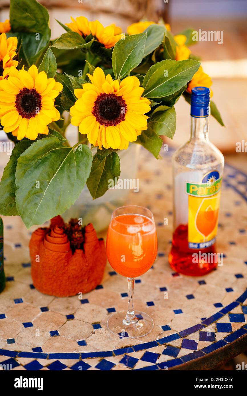 Aperol Spritz cocktail on a tabletop with sunflowers in a French pizza restaurant Stock Photo