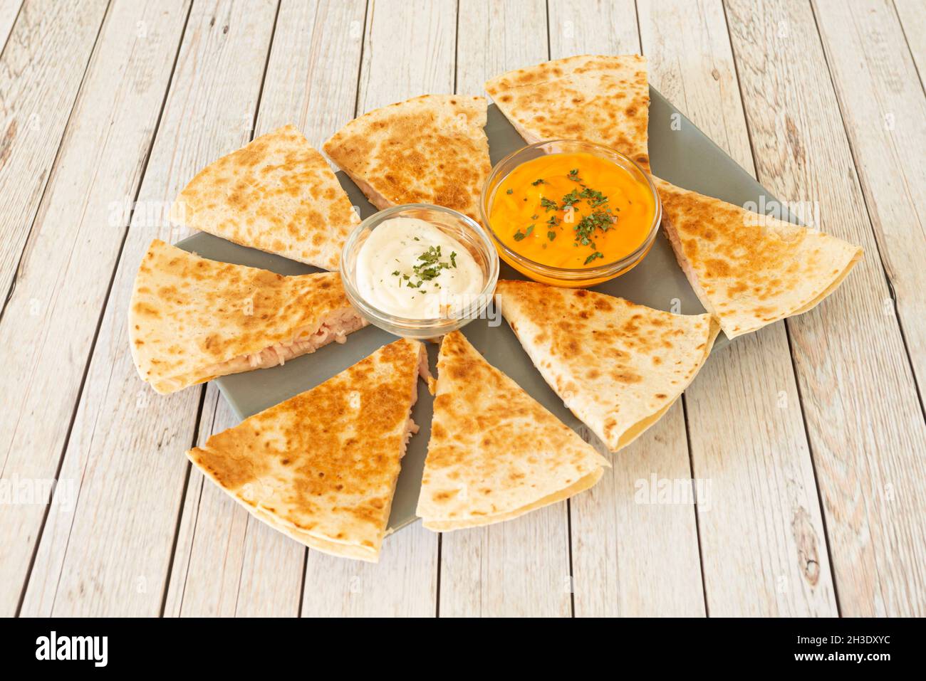 Synchronized shredded chicken quesadillas with cream cheese and cheddar