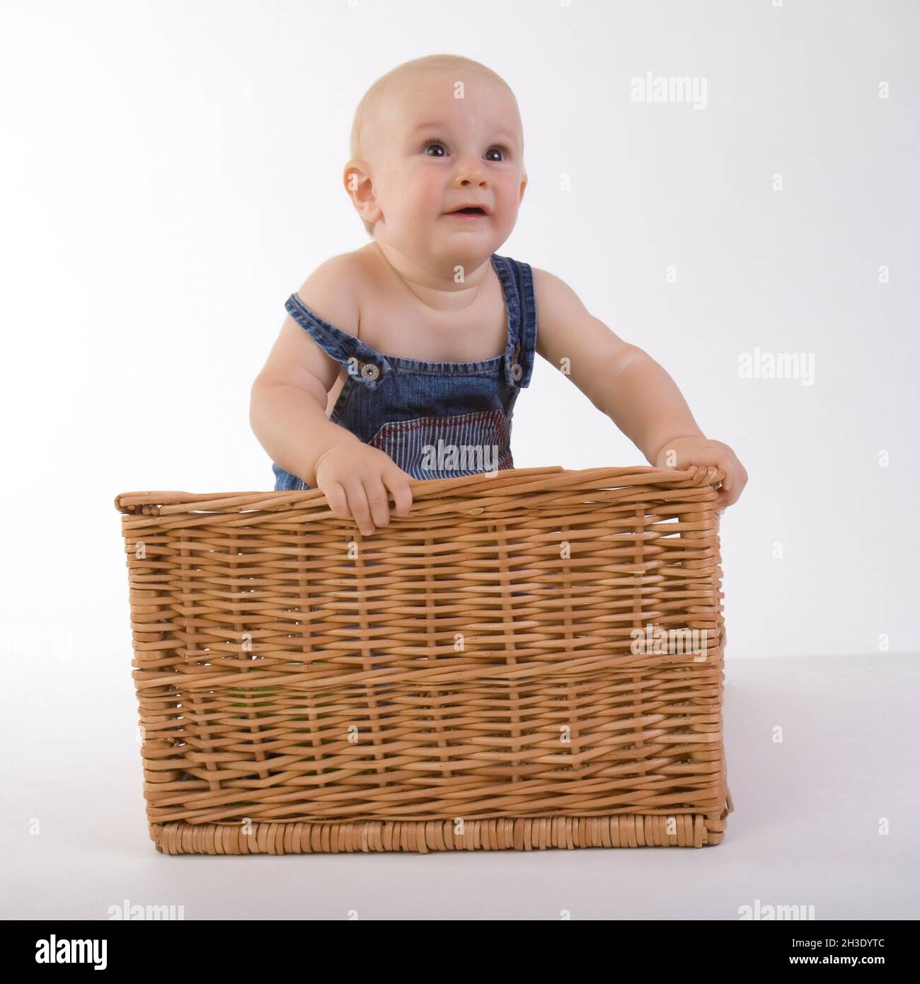 baby standing in a rattan basket Stock Photo