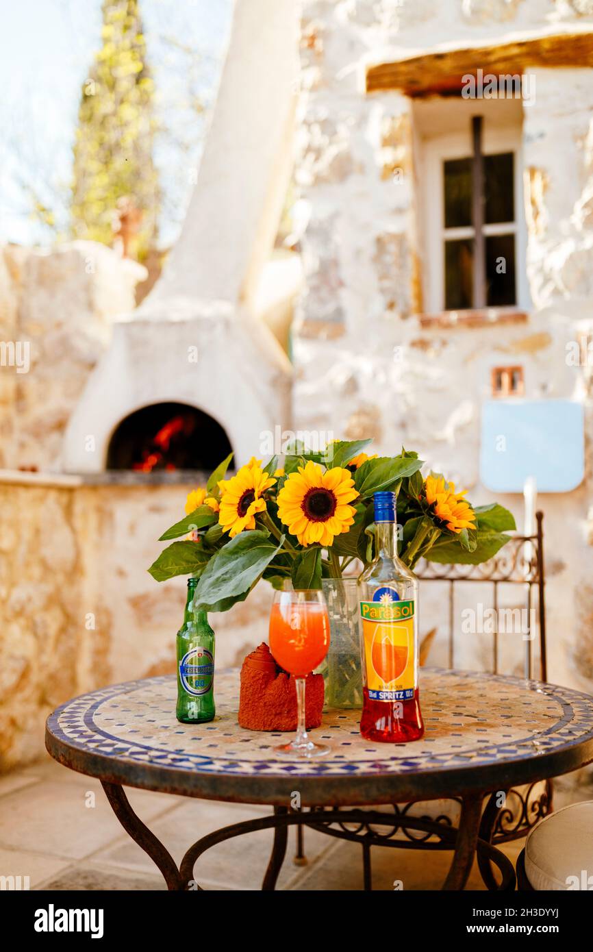 Aperol Spritz cocktail on a tabletop with sunflowers in a French pizza restaurant Stock Photo