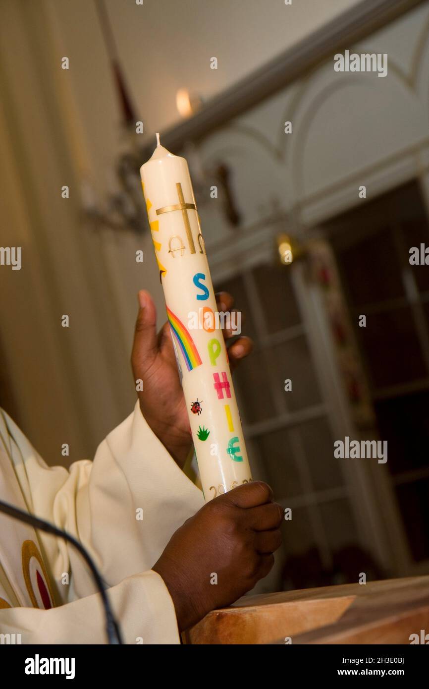 priest with christening candle , Austria Stock Photo