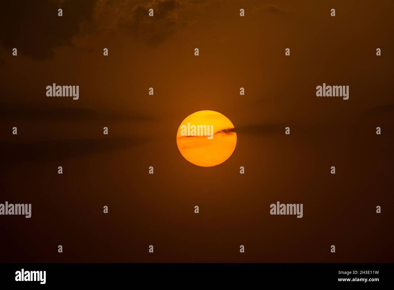 Astro sun through the clouds of a sunset on the beach Stock Photo - Alamy