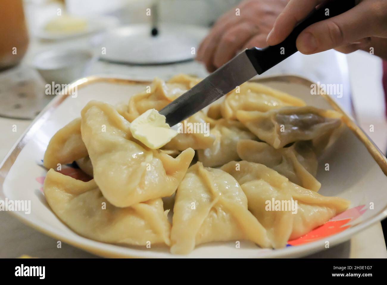 Ready manti on a dish are smeared with butter. No people Stock Photo