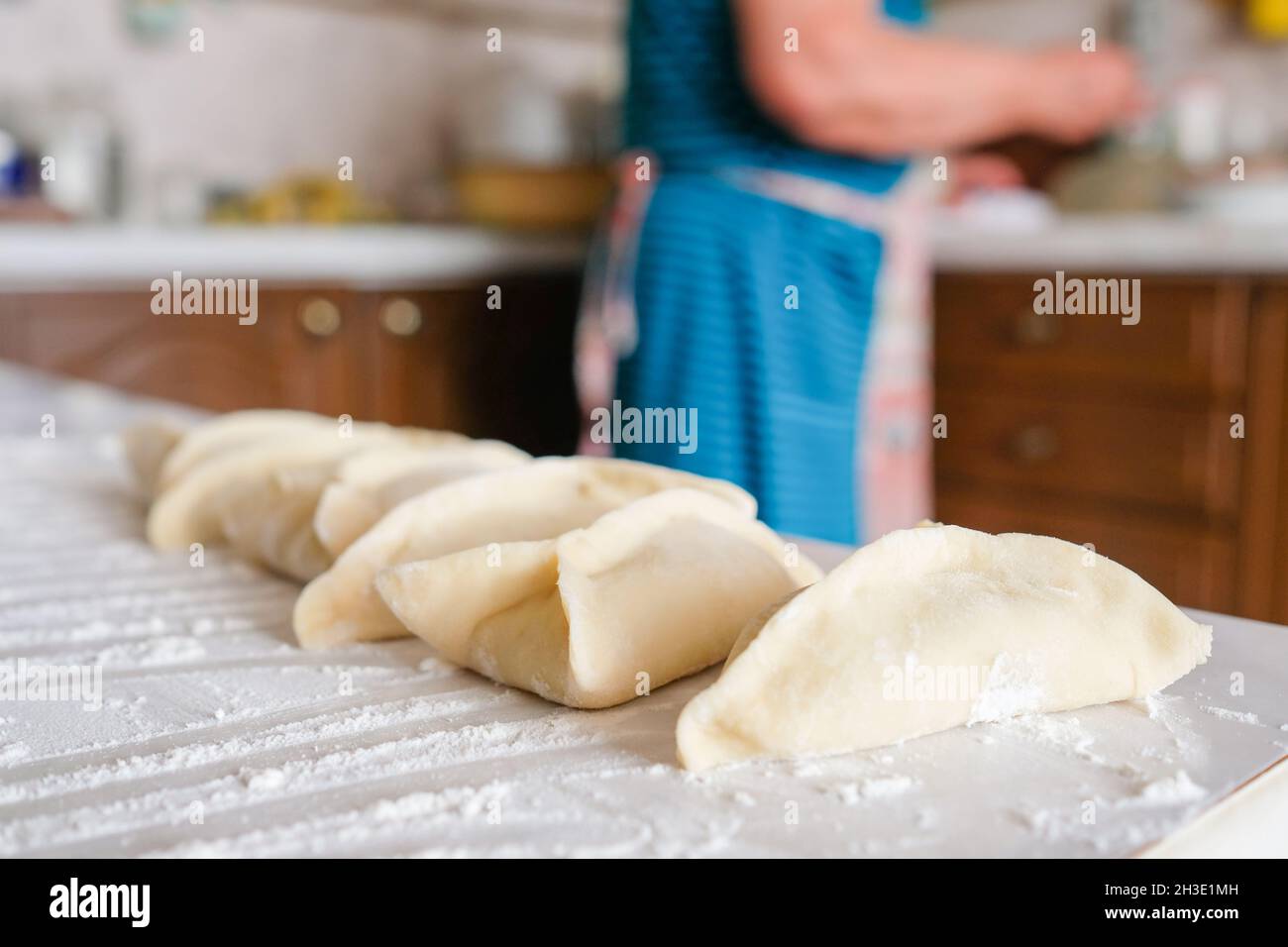 Triangular raw manti lie on the table. Cooking preparation Stock Photo