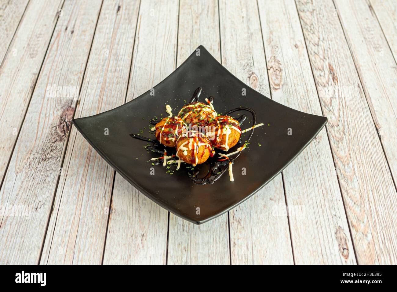 Tray of Japanese octopus takoyaki battered with soy sauce and chives