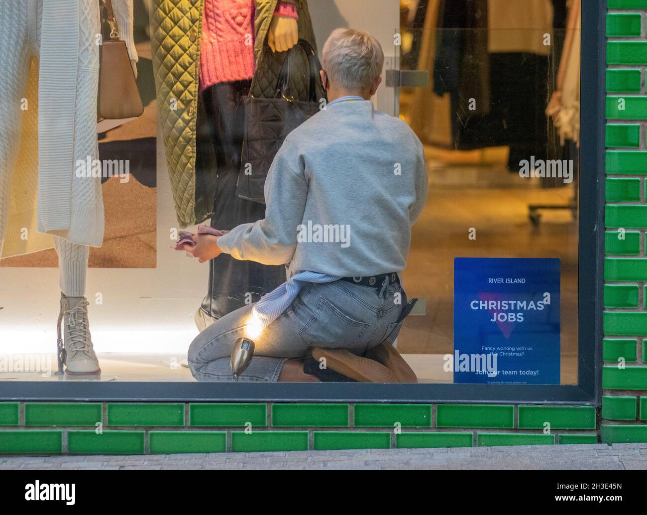 Female Window dresser making fashion adjustments in Fishergate, Preston