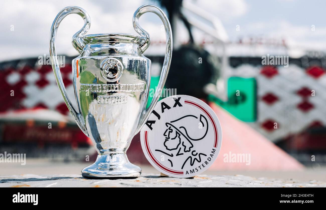 June 14, 2021 Amsterdam, Netherlands. The emblem of the AFC Ajax football club and the UEFA Champions League Cup against the backdrop of a modern stad Stock Photo