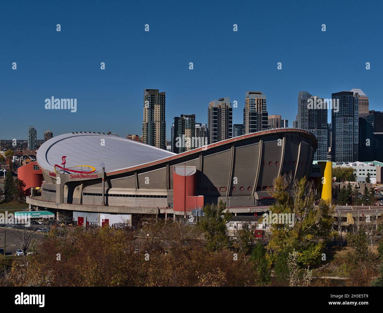 View of modern multi-use indoor arena Scotiabank Saddledome in Stampede Park, Calgary on sunny day in autumn season with skyline in background. Stock Photo