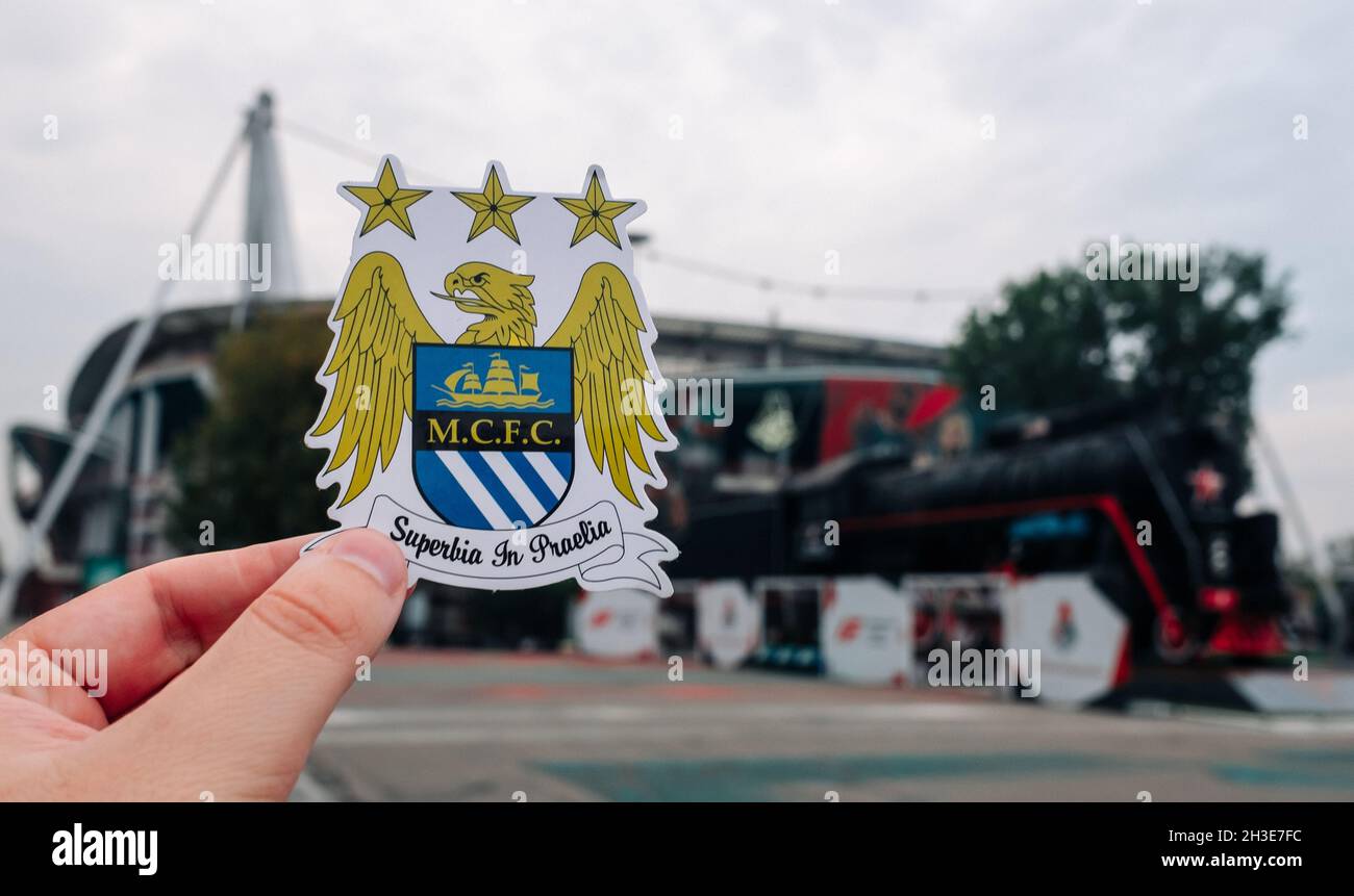 August 30, 2021 Manchester, UK. Manchester City F.C. football club emblem against the backdrop of a modern stadium. Stock Photo