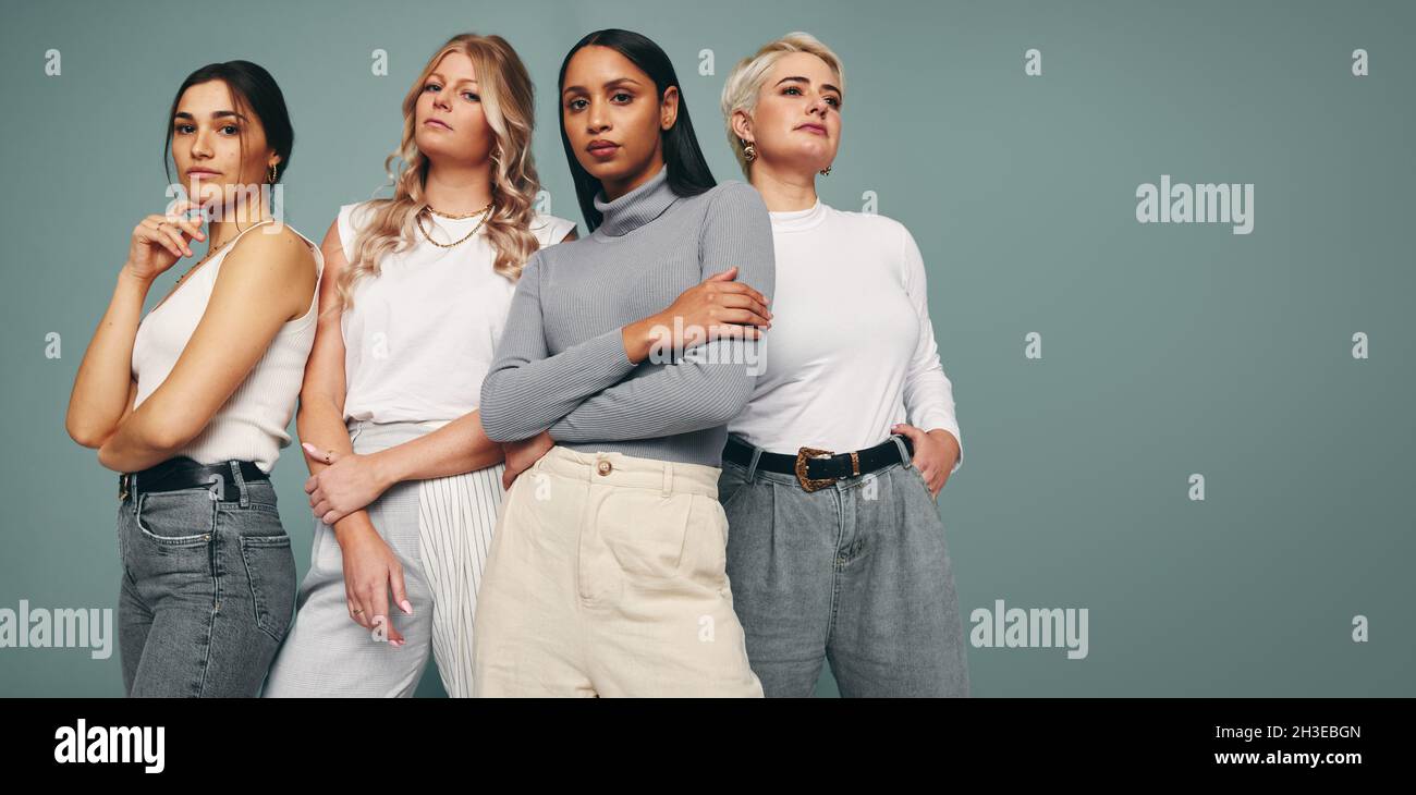 Style and confidence. Diverse group of empowered women standing together against a studio background. Self-confident female friends standing in a stud Stock Photo