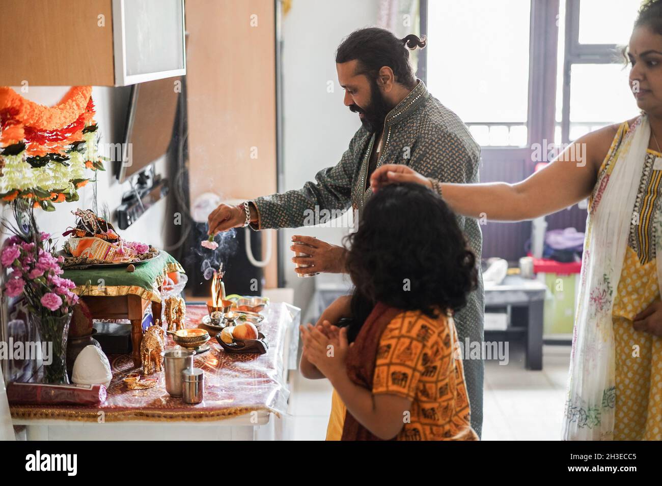 Indian family celebrating Diwali or hindu festival at home - Focus on father face Stock Photo