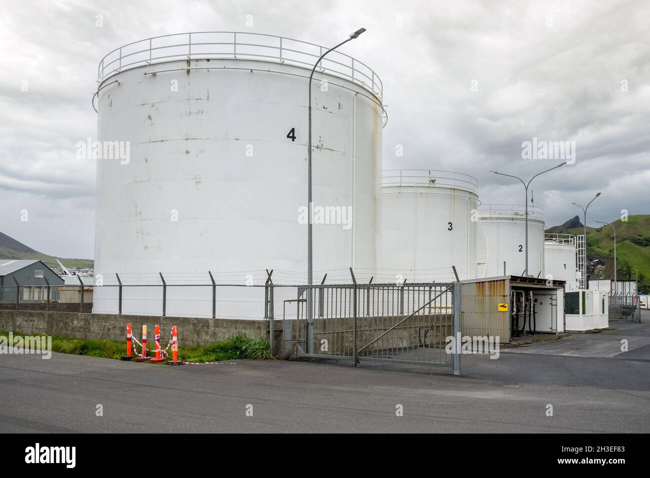 Huge white fuel tanks in an industrial park on a cloudy day Stock Photo