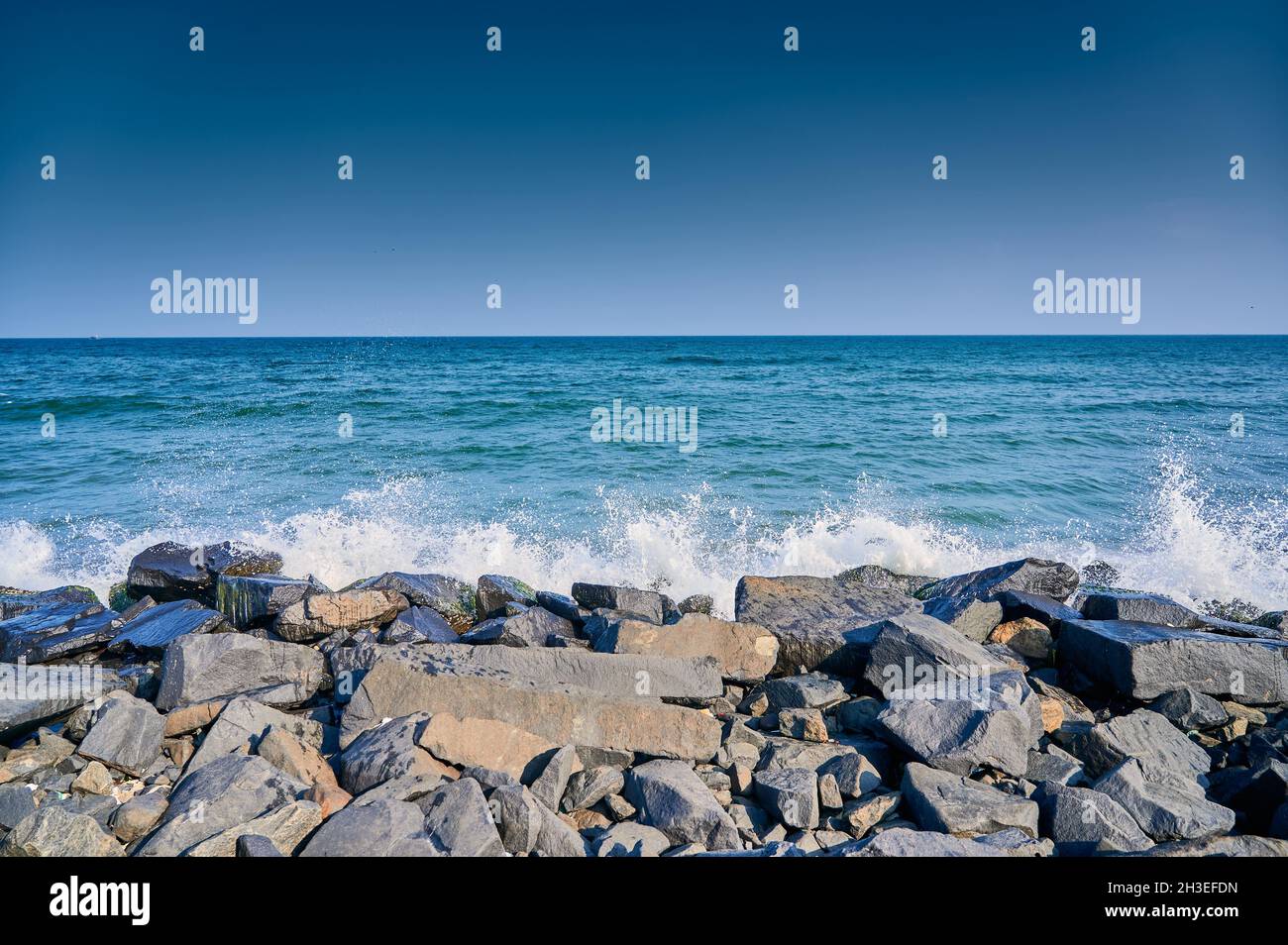 Stony beach with the splashes of sea waves Stock Photo - Alamy