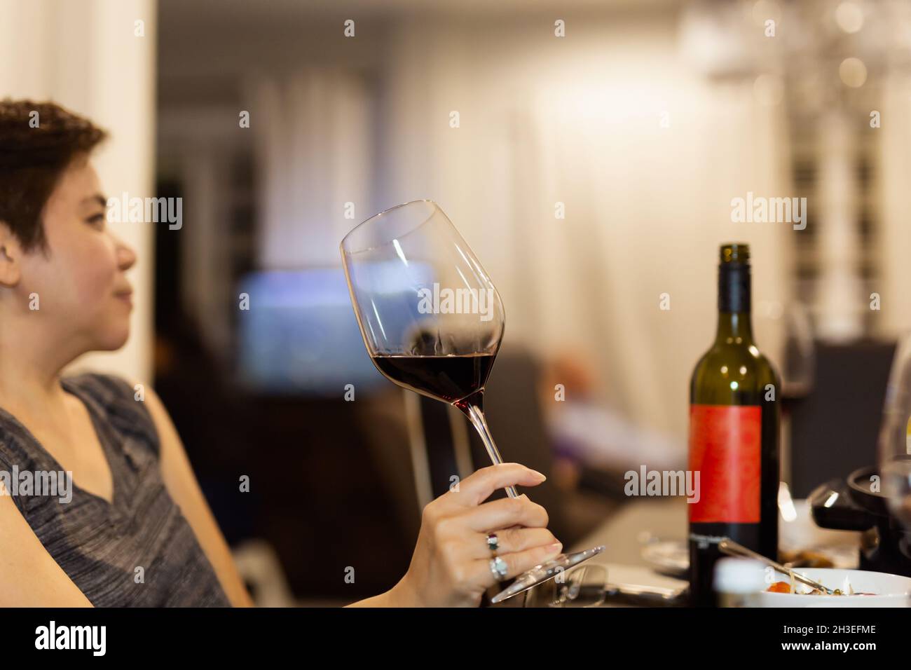 Female hand holding glass of red wine Stock Photo - Alamy