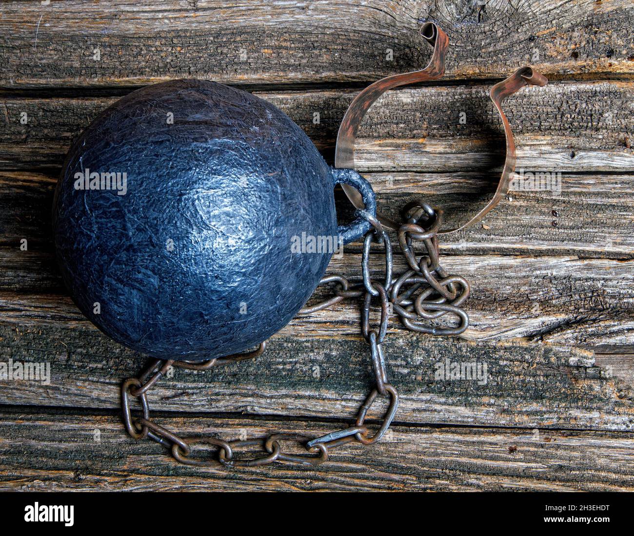 blank steel heavy prisoner ball on rough wooden table top view Stock Photo