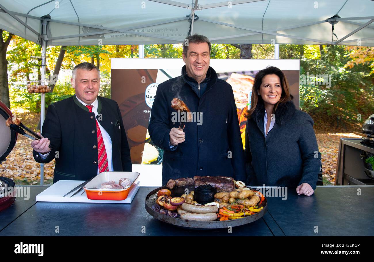 Munich, Germany. 28th Oct, 2021. Walter Heidl (l-r), President of the Bavarian Farmers' Association, Markus Söder (CSU), Minister President of Bavaria, and Michaele Kaniber (CSU), Minister of Agriculture of Bavaria, stand at a barbecue as part of the 'Grillen geht immer!' barbecue campaign. Credit: Sven Hoppe/dpa/Alamy Live News Stock Photo