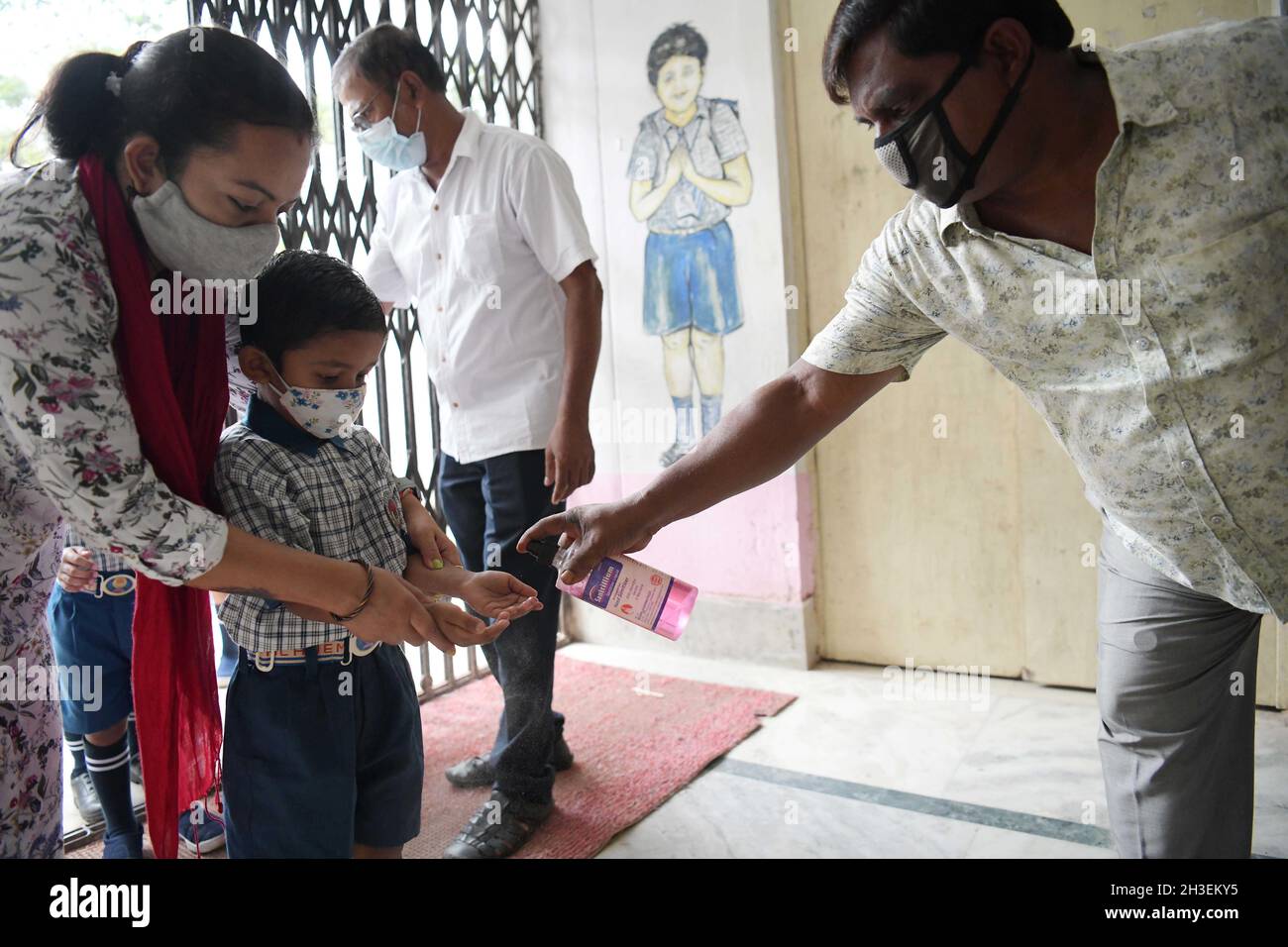 Agartala, India. 28th Oct, 2021. A student gets hands sanitized before entering the classroom on the first day of reopening of nursery sections in the schools after relaxation in COVID-19 restrictions in Agartala of Tripura, India, Oct. 28, 2021. Credit: Str/Xinhua/Alamy Live News Stock Photo